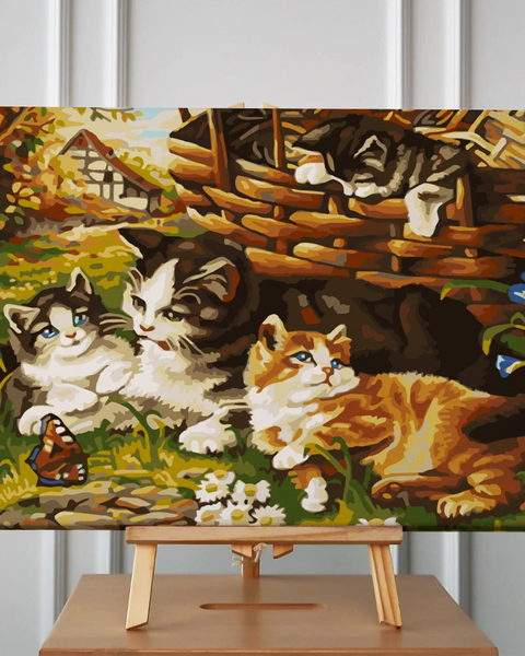 Painting of kittens relaxing in a garden near a wicker basket