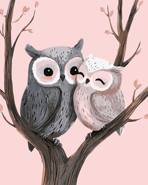 Two adorable owls cuddling on a tree branch with blossoms