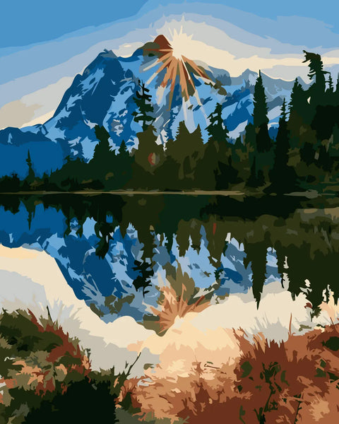 Mountain landscape with sunlit peak reflected in a tranquil lake
