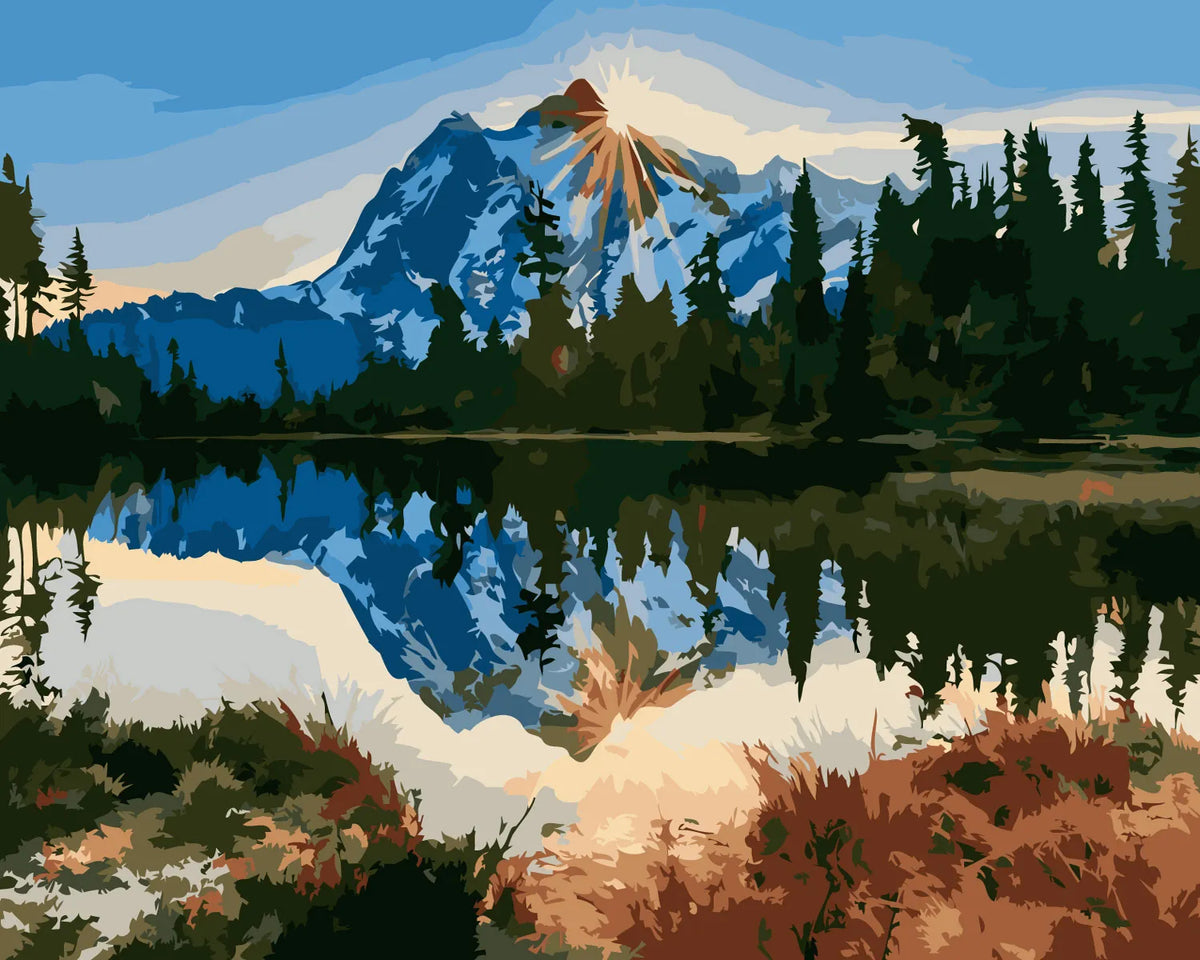 Mountain landscape with sunlit peak reflected in a tranquil lake