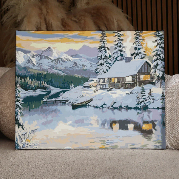 Painting of a cozy cabin in snowy mountains beside a lake