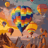 Colorful hot air balloons floating over a mountainous landscape at sunset