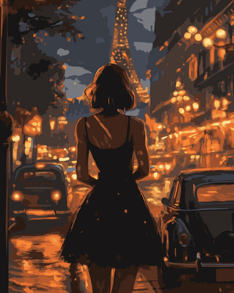 Woman in black dress walking through Paris streets at night