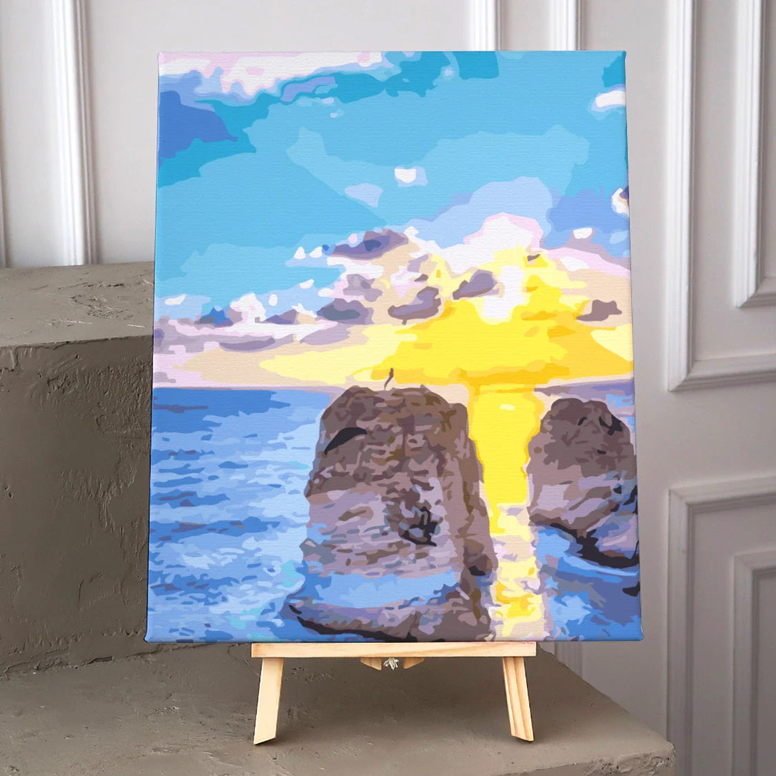 Colorful painting of a sunset over ocean cliffs with reflection