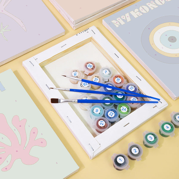 Coastal Dreams Paint by Numbers Kit by Artspark showing paint pots, brushes, and framed linen canvases with coastal-themed designs.