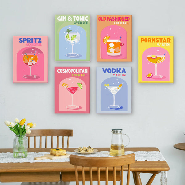 Cocktail Cuties Paint by Numbers Kit by Artspark displayed on a wall featuring six cocktail-themed canvases: Spritz, Gin & Tonic, Old Fashioned, Vodka Martini, Pornstar Martini, Cosmopolitan.