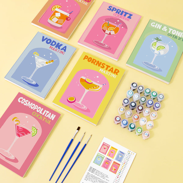 Cocktail Cuties Paint by Numbers Kit by Artspark showing six cocktail-themed canvases, paint pots, brushes, and layout guide.