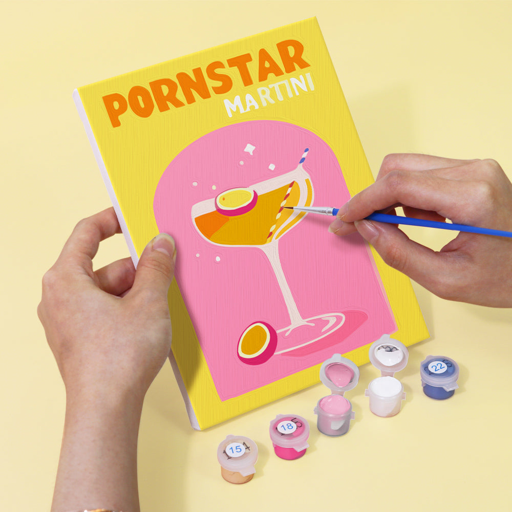 Painting a Pornstar Martini cocktail canvas from the Cocktail Cuties Paint by Numbers Kit by Artspark - Featuring bright colors, brushes, and numbered paints.