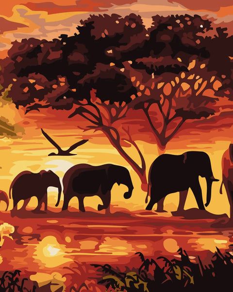 Elephants walking through an African savanna at sunset