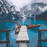 Scenic mountain lake with wooden dock and boats in calm water