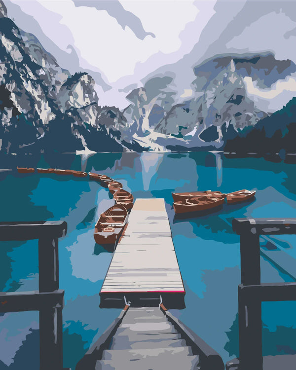 Scenic mountain lake with wooden dock and boats in calm water