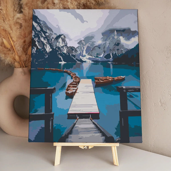 Scenic mountain lake with wooden dock and boats in calm water