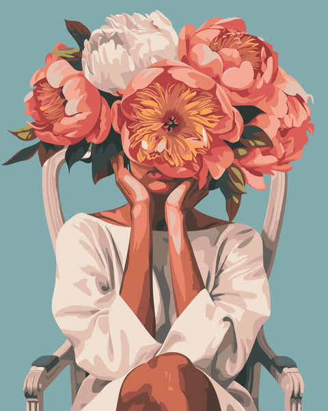 Woman sitting on chair with oversized flowers covering her face