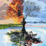 A tree depicting both summer and winter with a reflective lake