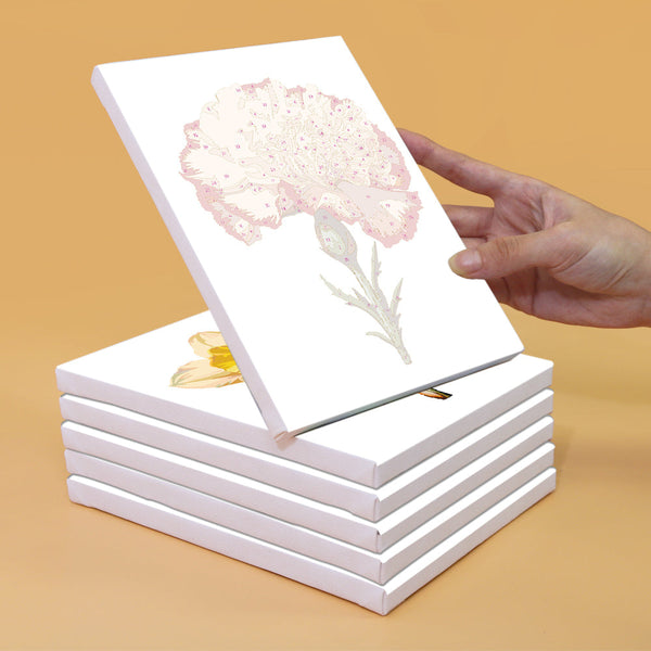 Unpainted canvas featuring a detailed outline of a carnation flower from the Garden Whispers Paint by Numbers Kit. Canvas stacked with others, highlighting the precision and quality of the Artspark kit.