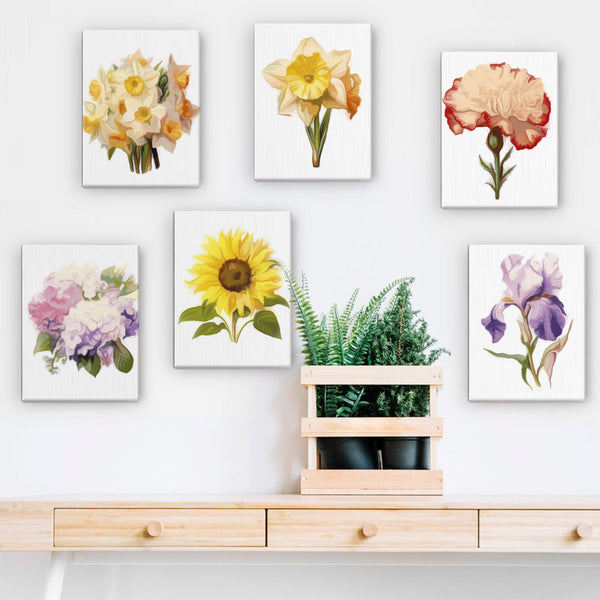 Six vibrant floral paintings from the Garden Whispers Paint by Numbers Kit displayed on a white wall above a wooden console with green plants. A beautiful decor arrangement showcasing botanical art. Artspark Paint by Numbers Kit.