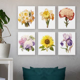 Six completed floral paintings from the Garden Whispers Paint by Numbers Kit displayed on a textured wall. Each canvas features a different flower, adding vibrant botanical charm to the room decor. Artspark Paint by Numbers Kit.