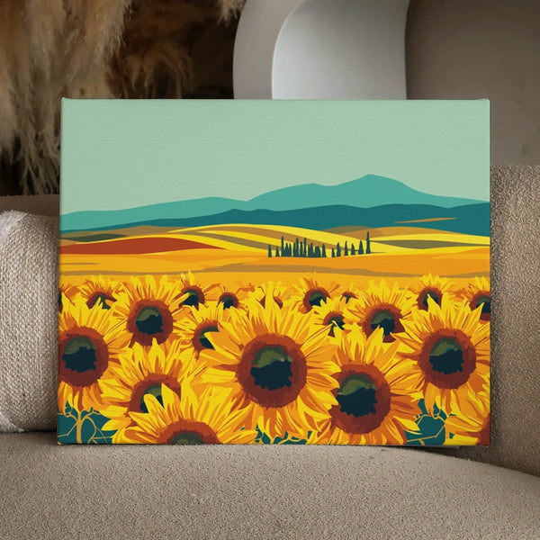 Vibrant sunflower field with rolling hills and mountains in background