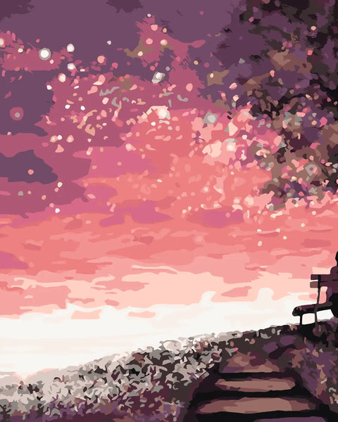 Silhouetted woman on a bench watching a dreamy pink sunset