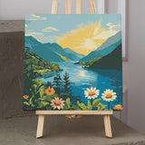 Scenic mountain lake painting with vibrant flowers and sunrise