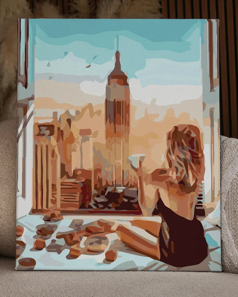 Woman enjoying coffee in bed with Empire State Building view