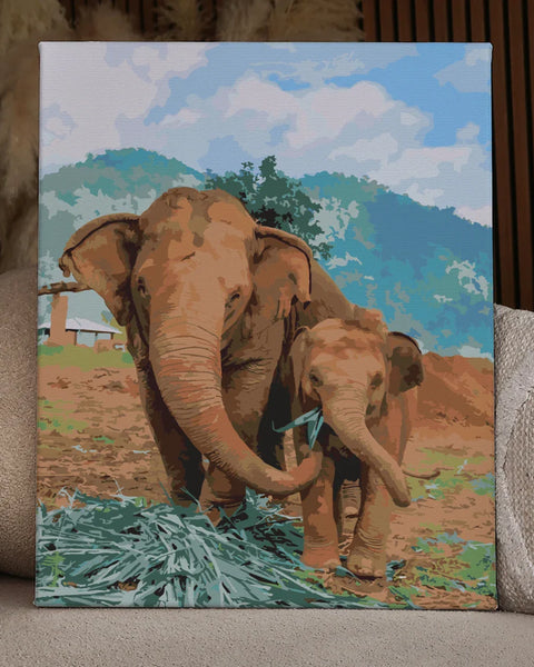 Mother and baby elephant eating in a lush mountainous landscape