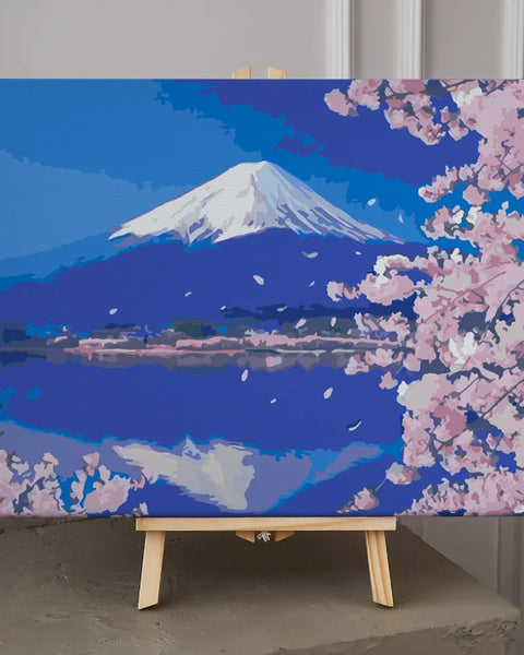 Snow-capped Mount Fuji with cherry blossoms and serene lake reflection