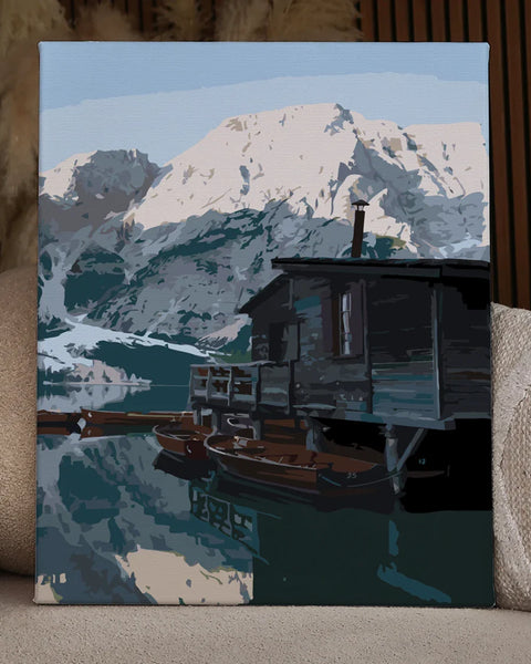 Rustic cabin by a mountain lake with wooden boats