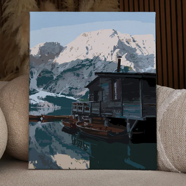 Rustic cabin by a mountain lake with wooden boats