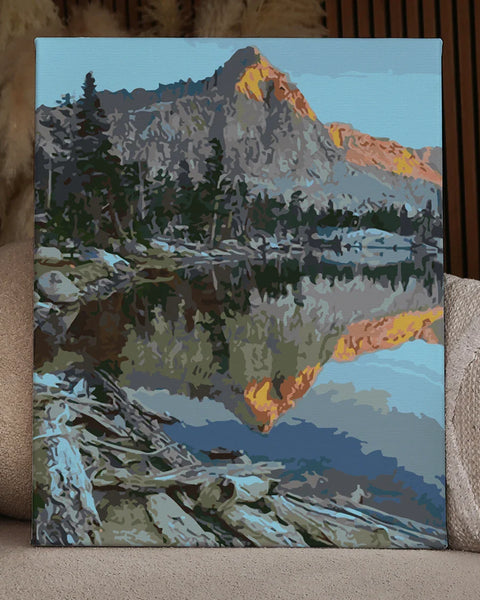 Mountain landscape reflecting in a calm lake at sunrise
