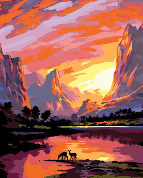 Majestic sunset over mountains with deer by a reflective lake