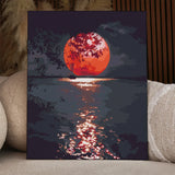 Sailboat on water with glowing red sunset and tree silhouette painting
